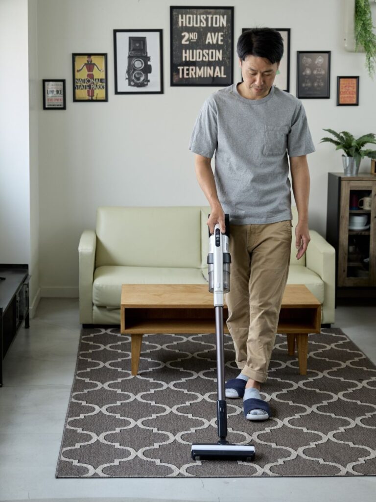 family performing weekly cleaning tasks – vacuuming floors and managing laundry